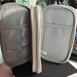 Silver Travel Bag for Charger, Plugs, and Earbuds.